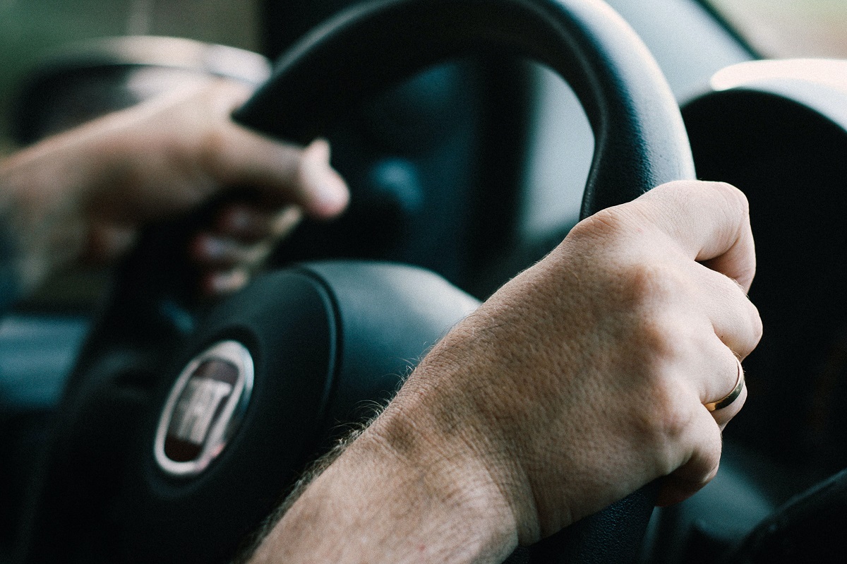 hands in defensive position on steering wheel