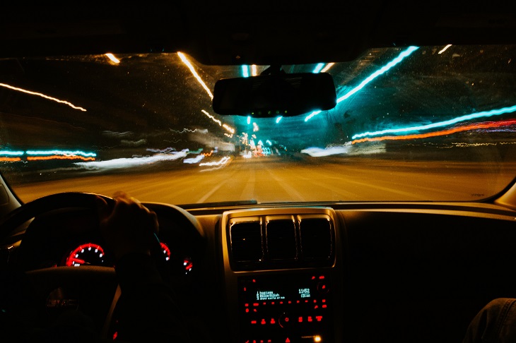 person driving car on empty road at night