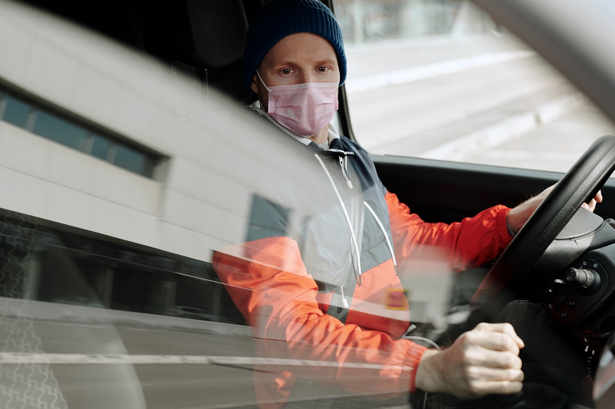 person driving car wearing mask