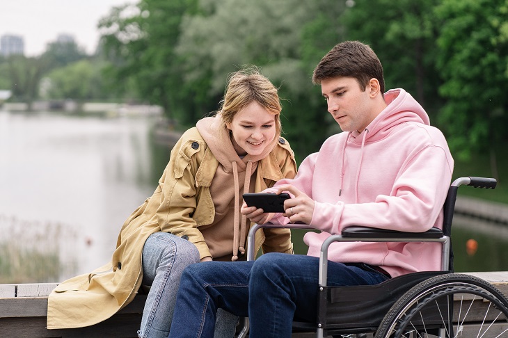 person in wheelchair using phone